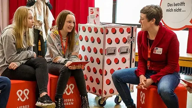 Auftakt der bundesweiten Schultour „LIEBESLEBEN – Das Mitmach-Projekt“ an der Gesamtschule Köln-Holweide am 4. Februar 2020. zwei junge Frauen im Gespräch mit einer Moderatorin
