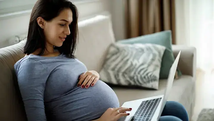 Schwangere Frau recherchiert am Laptop Schwangere Frau recherchiert am Laptop