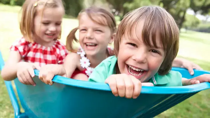 Lachende Kinder in Schubkarre