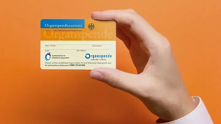 Hand, die Organspendeausweise hochhält