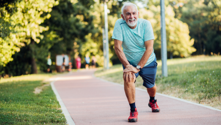 Älterer Mann macht bei Sonnenschein Sport im Park.